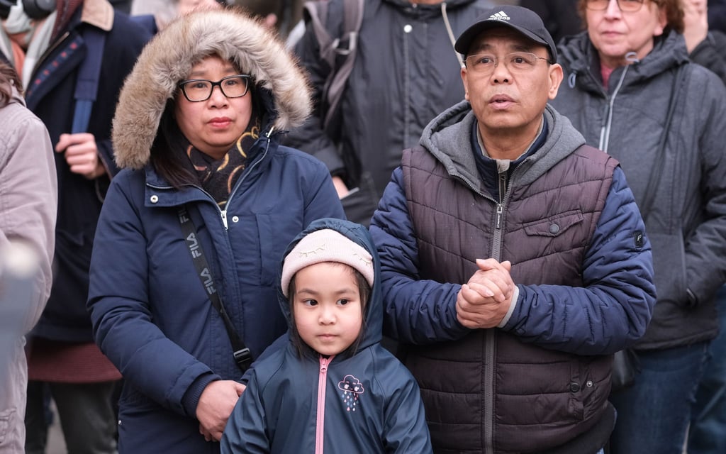 Hoa Nguyen, Tochter Emilia und Pham Phi Son, eine vietnamesische Familie aus Chemnitz, steht bei einer Kundgebung beisammen.
