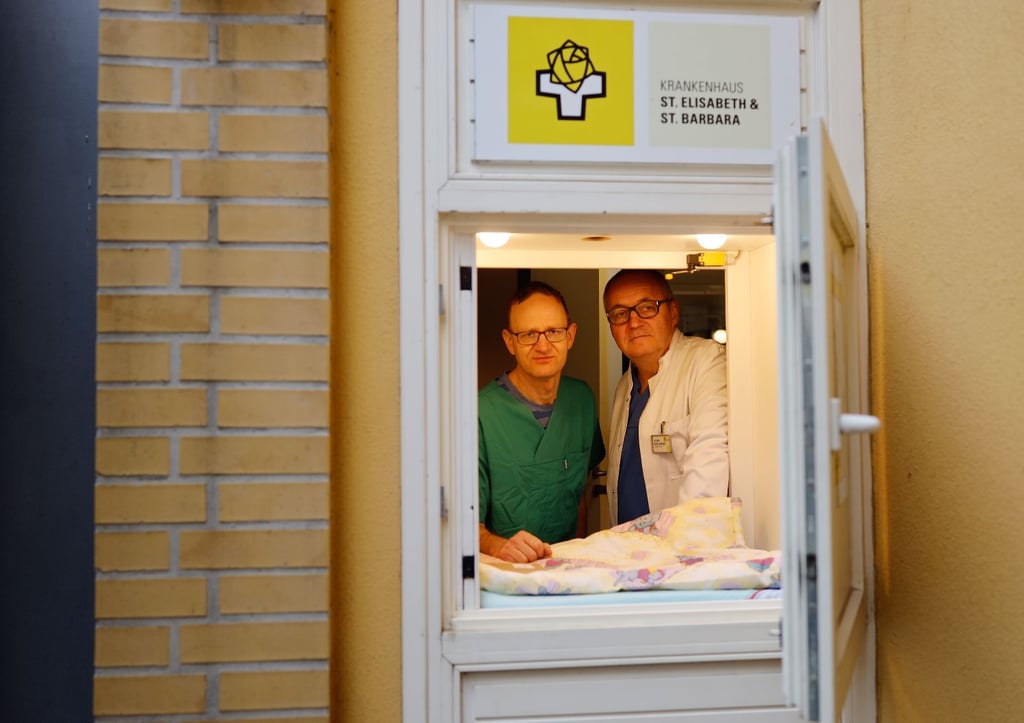 Bietet ungewollten Neugeborenen Zuflucht: Die Chefärzte Roland Haase (l.) und Sven Seeger blicken von innen aus dem Babynest am Krankenhaus St. Elisabeth und St. Barbara.