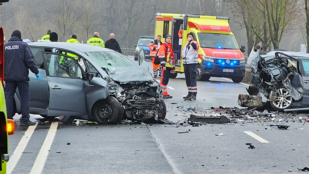 Rettungsdienste, Polizei und Sachverständige stehen zwischen Autowracks.