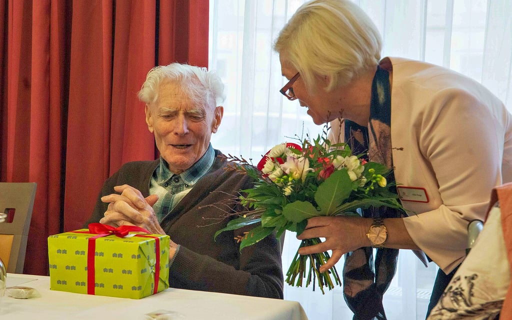 Regionalleiterin Silke Klage beschenkt zur Feier 10 Jahre K&S Seniorenresidenz Siegfried Zäper als langjährigen Hausbewohner.
