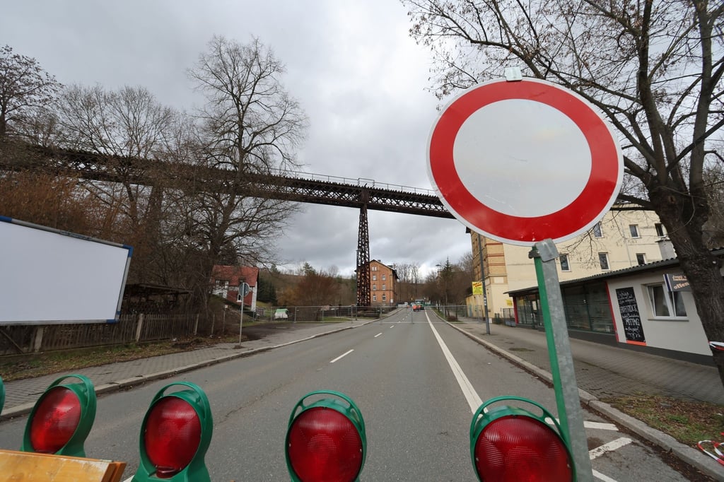 Sperrvorrichtungen stehen auf der Bundesstraße B92 vor einer Eisenbahnbrücke.