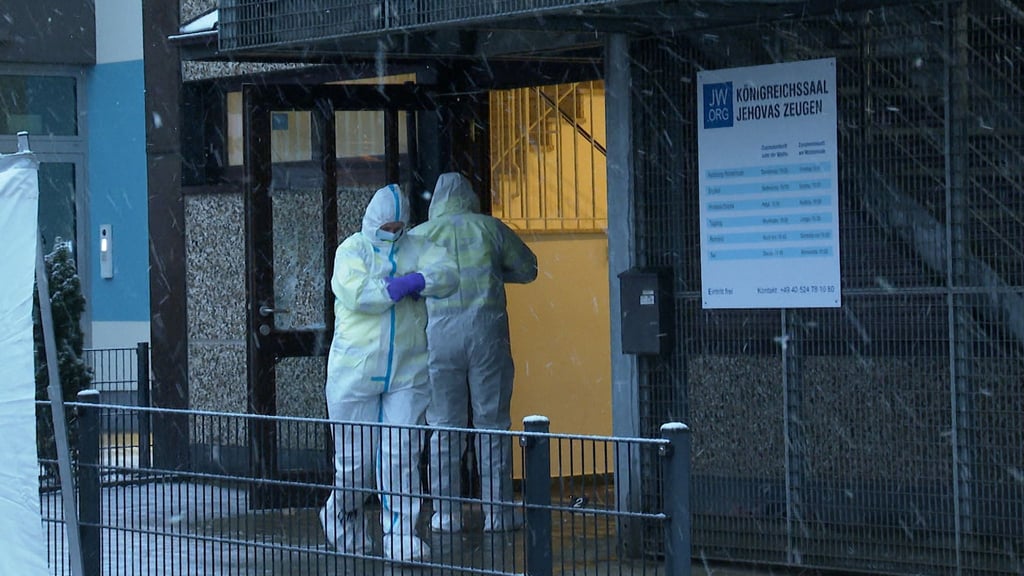 Ermittler stehen am Morgen vor dem Gebäude der Zeugen Jehovas in Hamburg, in dem mehrere Menschen getötet wurden.