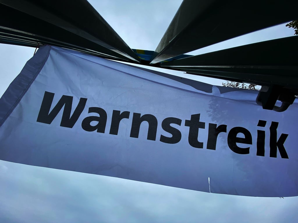 "Warnstreik" steht auf einem Transparent.