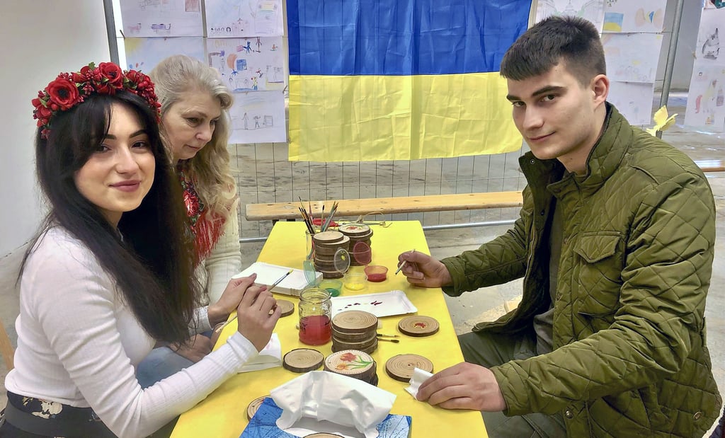 Mit Malerei aus Petrykiwka – Weltkulturerbe – kann man sich ein ukrainisches Souvenir herstellen, hier Lolita Tuchak mit Florian Pohle.