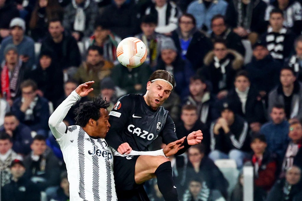 Freiburgs Lucas Höler (r) und Turins Juan Cuadrado im Kopfballduell.
