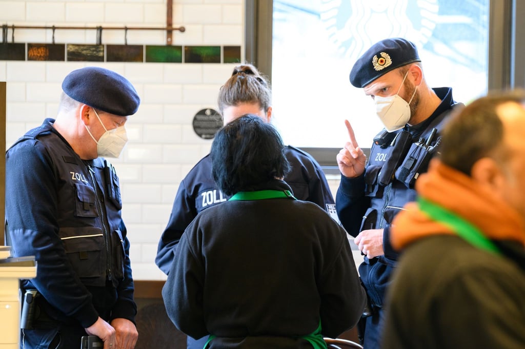 Zollbeamte kontrollieren die Mitarbeiter eines Cafés.