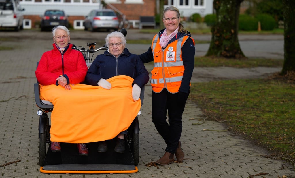 Ute Wischmann-Lübbers (r) steht neben der Rikscha mit Brigitte Görlich (l) und Elisabeth Lübbers.