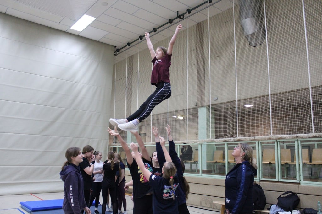 Die „Princess Cheerleader“ des Sportvereins Empor Grün/Rot Wittenberge trainieren den „Basket Toss“. Dabei wird der sogenannte „Flyer“ in die Luft geworfen und vollzieht dort eine akrobatische Figur.