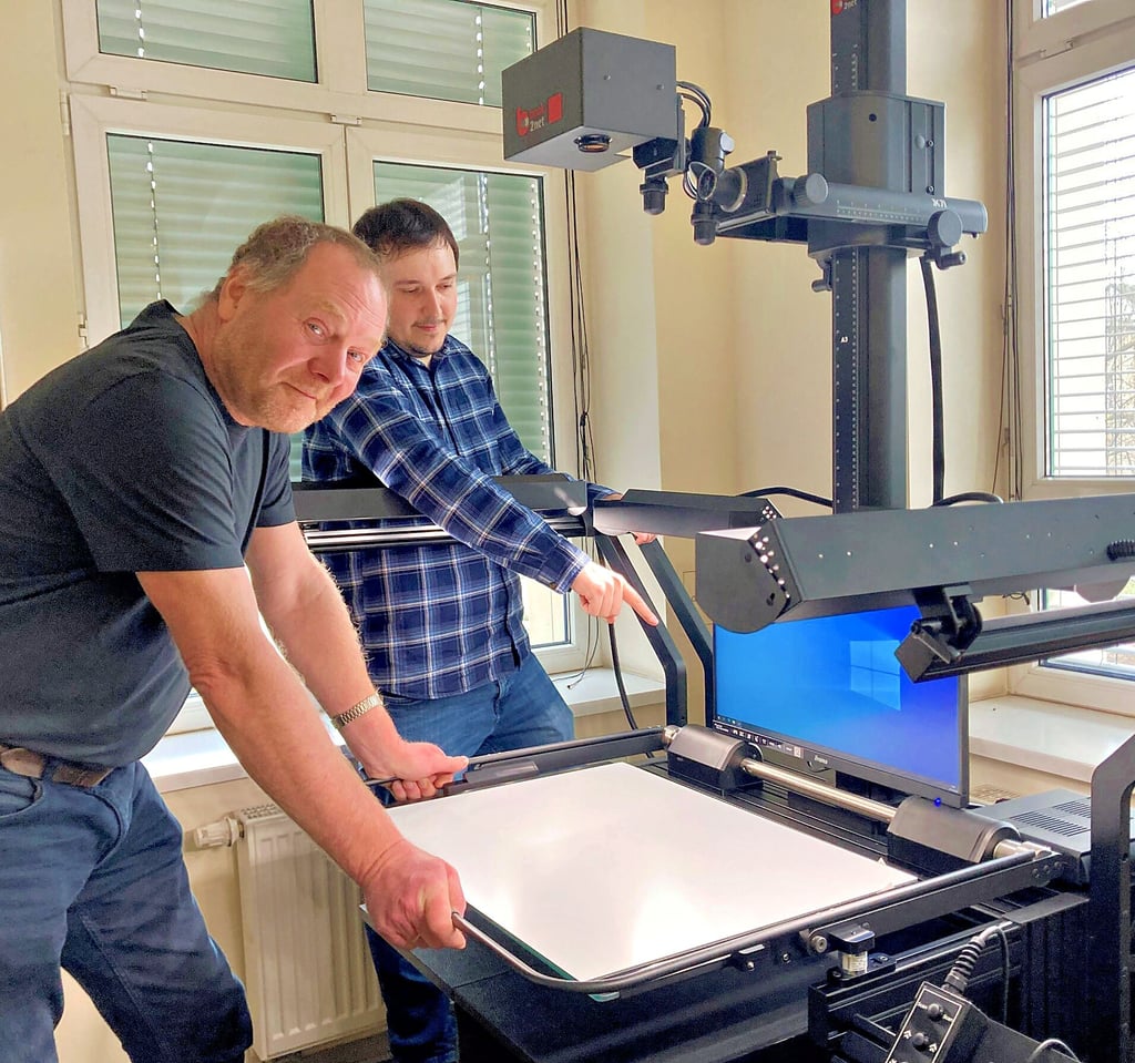 Bernhard Just, Leiter des Naumann-Museums (li.), und Pierre Kohlmann von der Herstellerfirma Microbox aus Bad Nauheim besprechen die Funktionsweise des neuen Buchscanners.