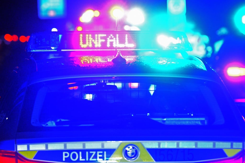 Ein Streifenwagen der Polizei steht mit Blaulicht an einer Unfallstelle.