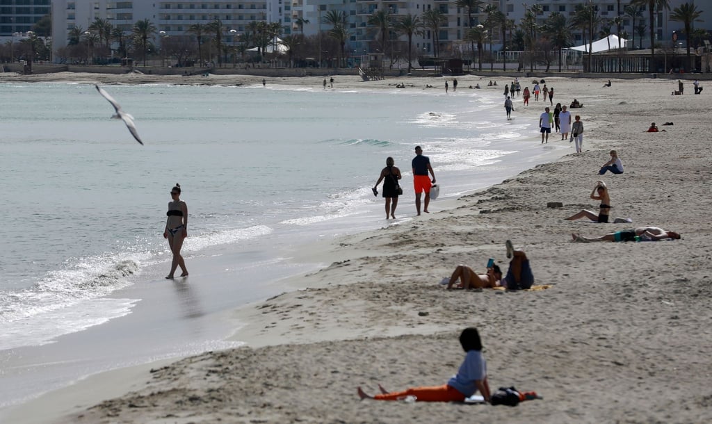 Menschen sonnen sich am Strand von Cala Millor auf Mallorca.