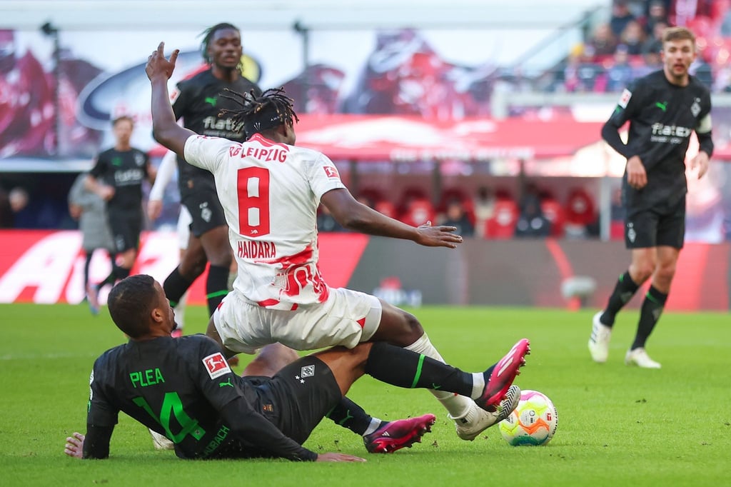 Alassane Plea (l) bringt Leipzigs Amadou Haidara im Strafraum zu Fall.