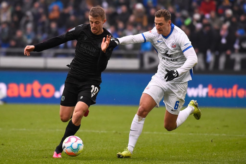 Hannovers Sebastian Ernst (l.) im Laufduell mit Dennis Dressel von Hansa Rostock.