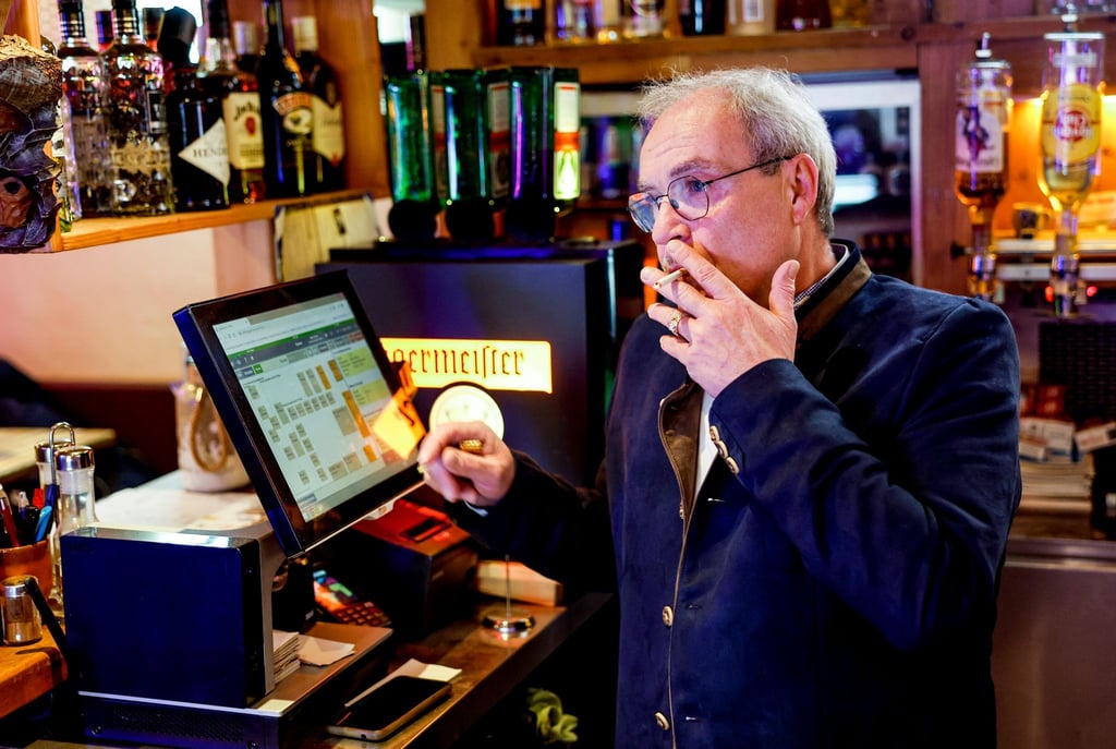 Peter Krall, Inhaber des „Hofbräu Raucher Stüberl“ in Hamburg, raucht am Tresen seines Lokals eine Zigarette.