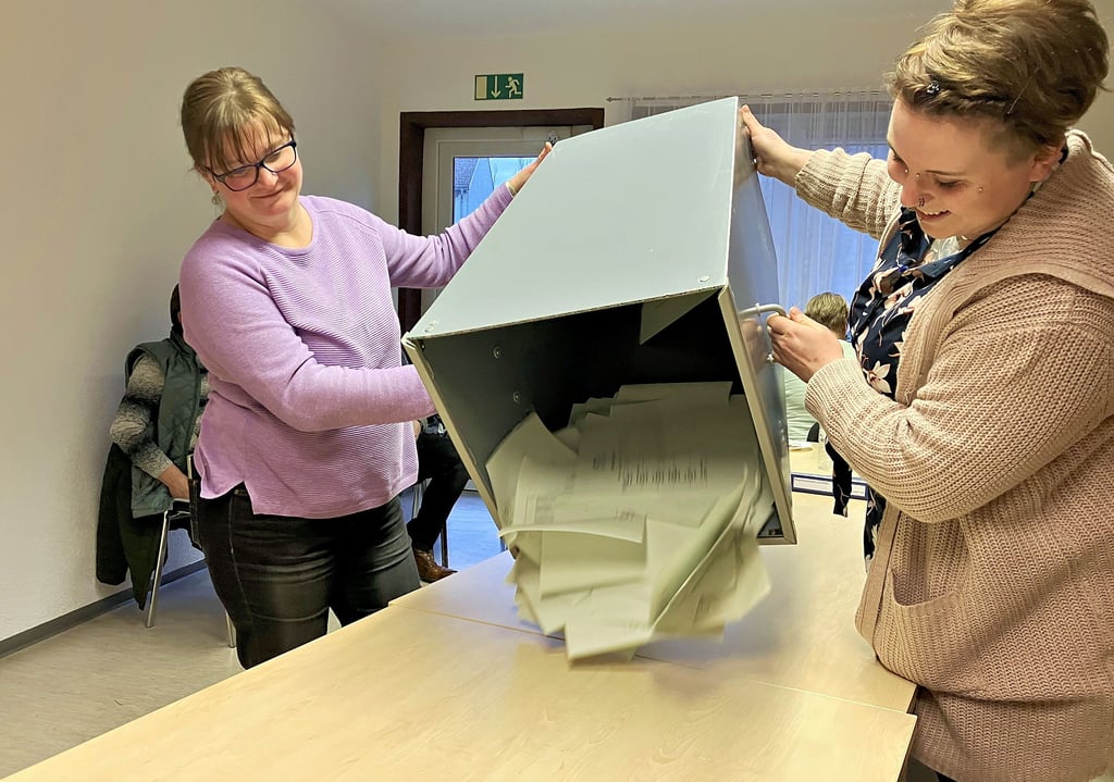 Endorfs Wahlvorsteherin Dorit Bialke (links) und eine weitere Ehrenamtliche leeren die Wahlurne aus. Jetzt kann gezählt werden.