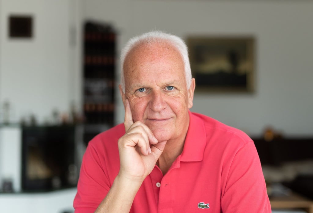 Bernd Stange, ehemaliger Trainer der DDR Fußball Nationalmannschaft, sitzt an einem Tisch in seinem Haus.