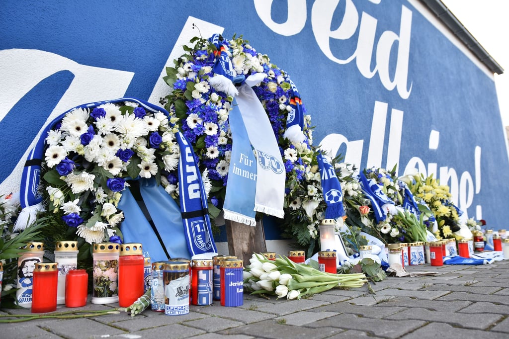 Vor der „Ihr seid niemals alleine“–Wand an der Heimspielstätte des FCM in Magdeburg drücken Fans ihre Anteilnahme aus.
