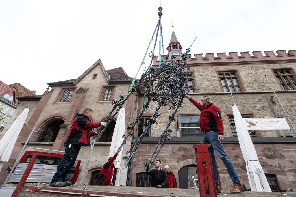 Steinmetze legen den Baldachin vom Gänselieselbrunnen auf einen Transportanhänger.