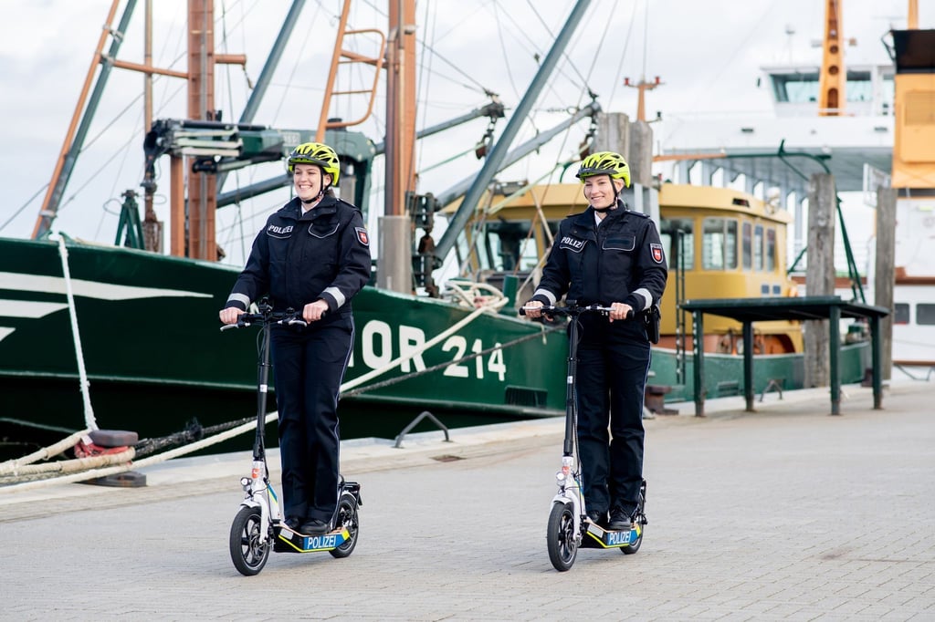Zwei Streifenpolizistinnen fahren bei einem Pressetermin mit E-Scootern der niedersächsischen Polizei.