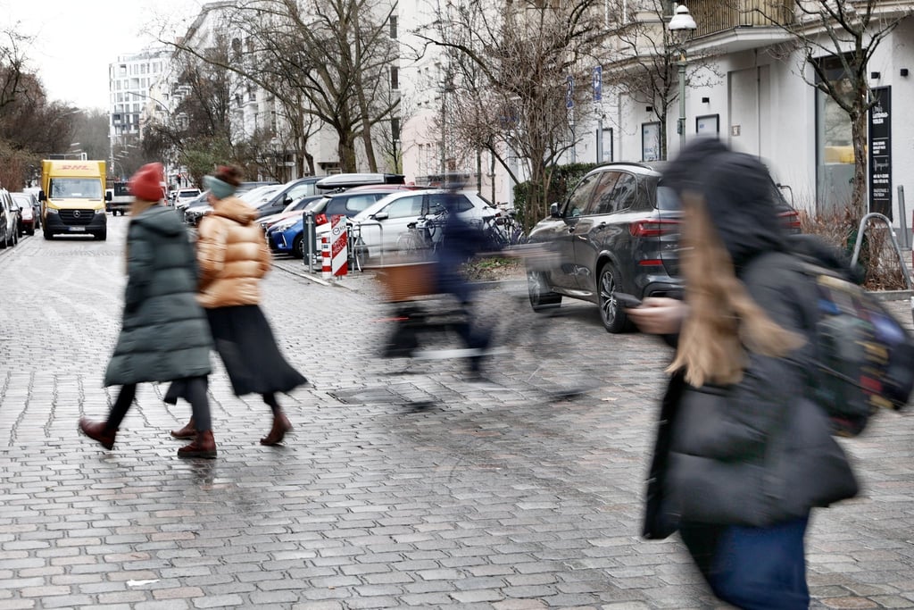 Fahrradfahrer und Fußgänger überqueren eine Straßenkreuzung im Graefekiez.