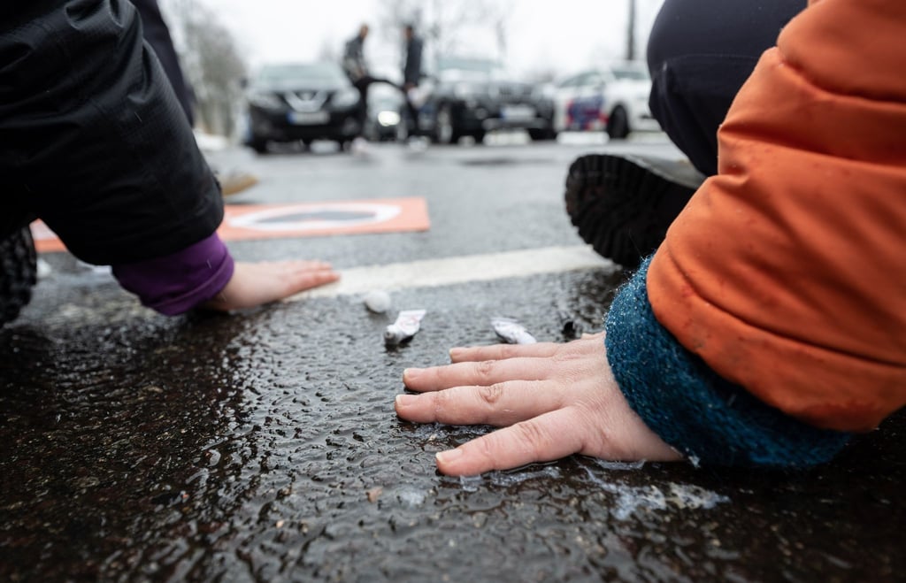 Mit Sekundenkleber haben sich zwei Aktivistinnen der Letzten Generation auf der Fahrbahn der Jahnallee in Leipzig festgeklebt.