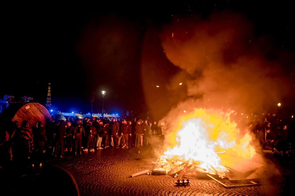 Demonstranten stehen neben einer brennenden Barrikade auf dem Place de la Concorde in Paris.