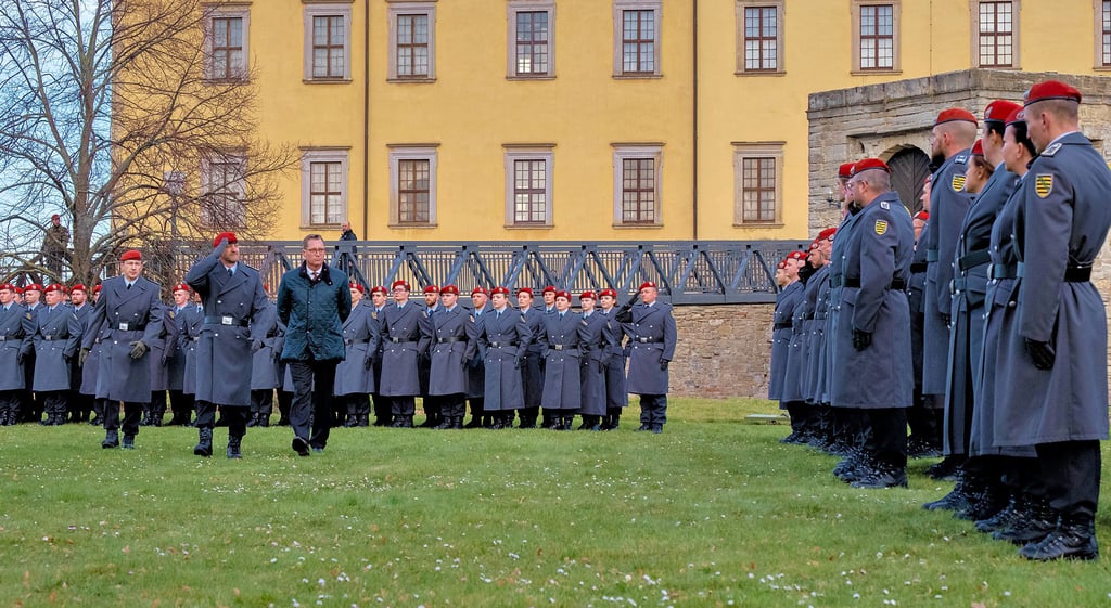 Oberbürgermeister Christian Thieme (CDU, in zivil) und Kommandeur Daniel Spieß (links neben Thieme) schreiten vor Schloss Moritzburg an den angetretenen Soldaten vorbei.