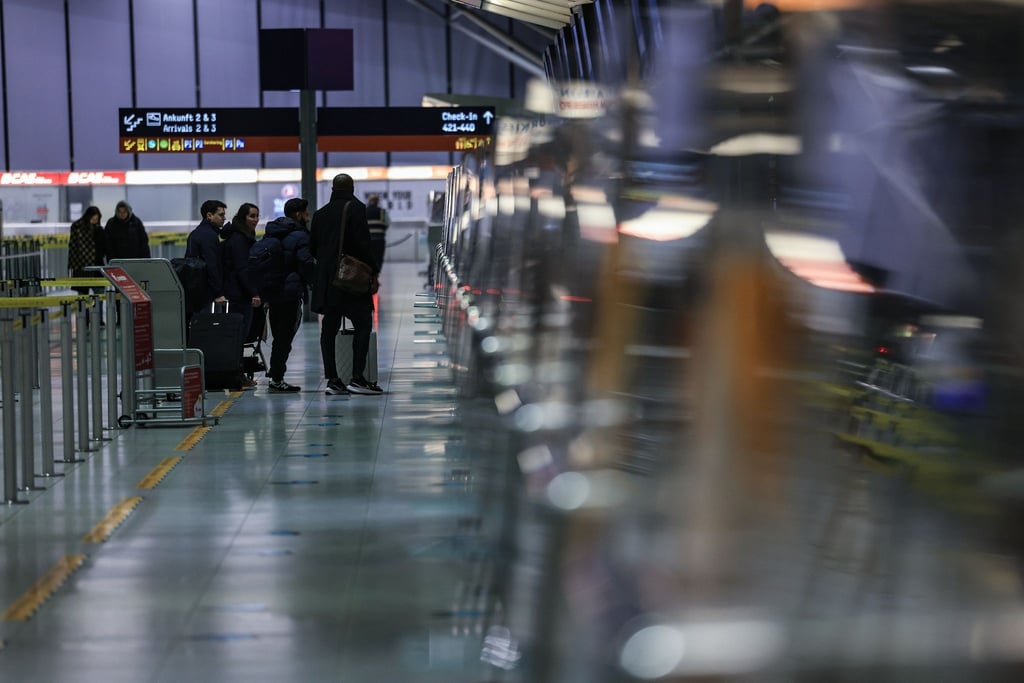 Reisende stehen am Flughafen Köln/Bonn vor einem Schalter.