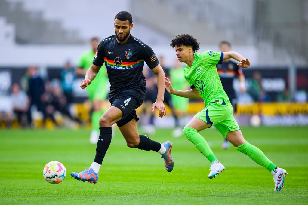 Stuttgarts Josha Vagnoman (l) schirmt den Ball vor Wolfsburgs Kevin Paredes (r) ab.