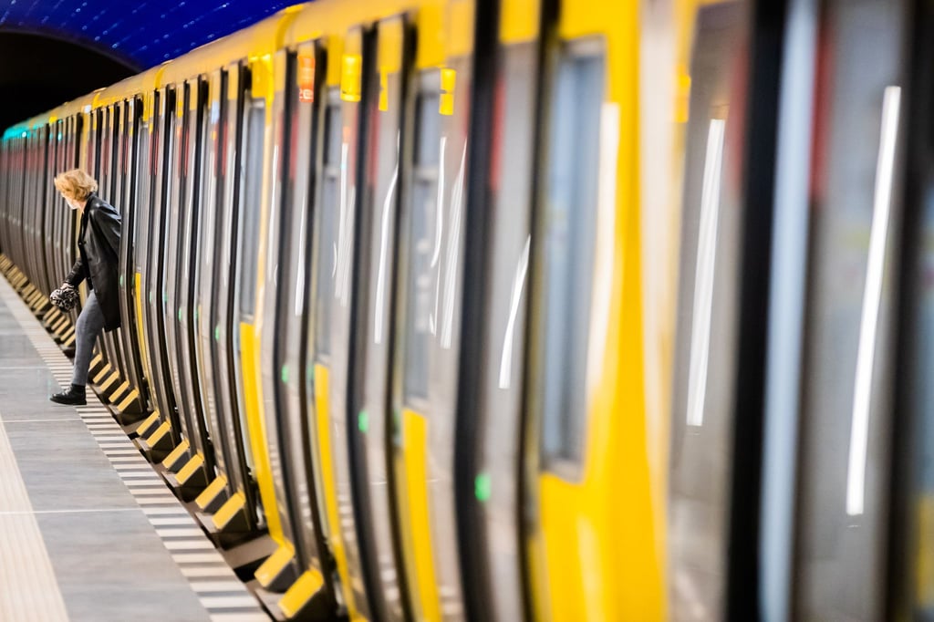Eine Frau steigt an einem U-Bahnhof aus.