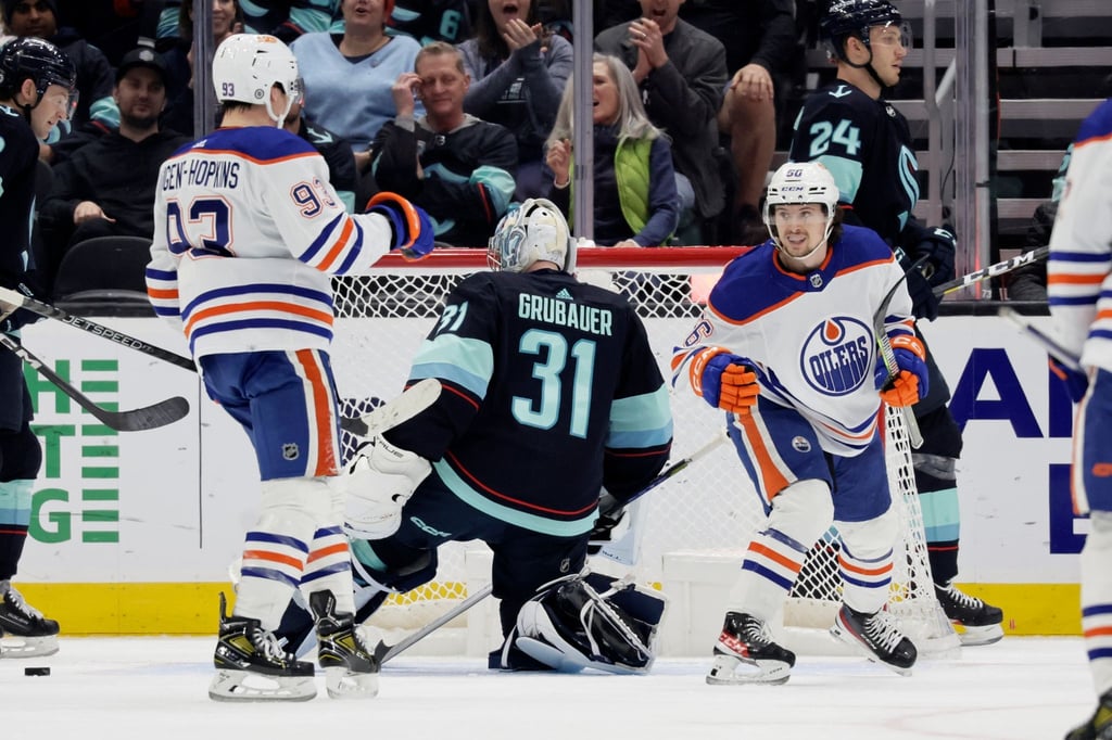 Kailer Yamamoto (r) und Ryan Nugent-Hopkins (l) von den Edmonton Oilers feiern nach dem Treffer gegen den Torwart der Seattle Kraken, Philipp Grubauer.