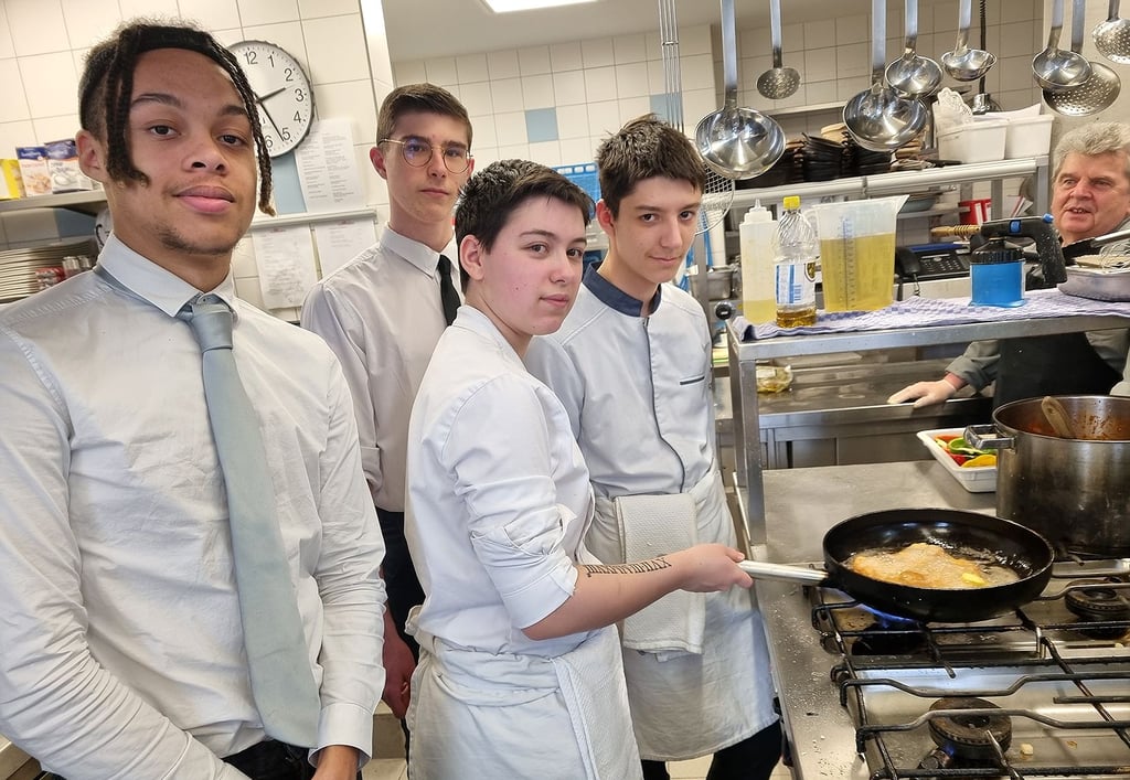 Hier sind die vier französischen Auszubildenden in der Küche des Havelberger Hotels zu sehen: Matéo Stevant und Matheo Devarenne (hinten) und Tiago Chapillon und Rémi Bazin (rechts), die gerade ein Schnitzel in der Pfanne haben.