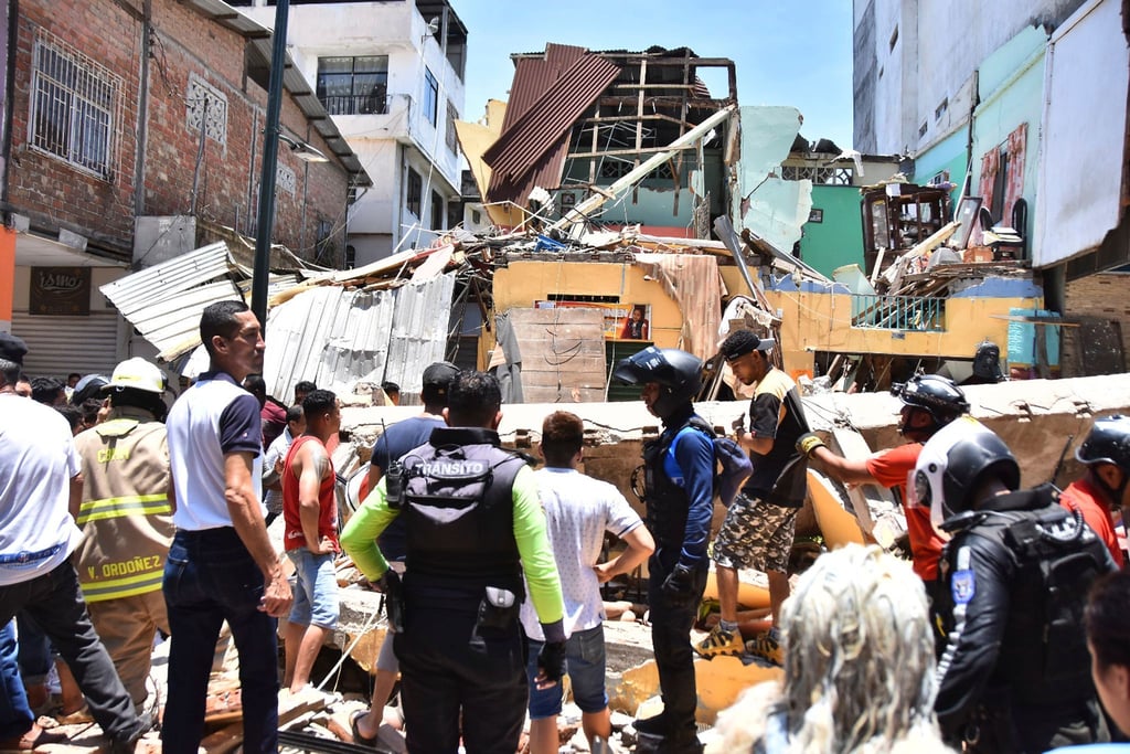 Anwohner und Rettungskräfte stehen vor zerstörten Gebäuden in Machala.