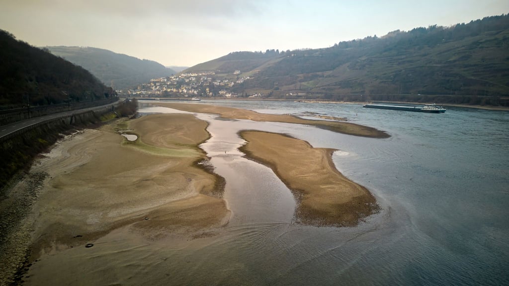 Schiffe passieren bei einem für die Jahreszeit ungewöhnlich niedrigen Wasserstand die Sandbank am Jungfrauengrund am Mittelrhein.