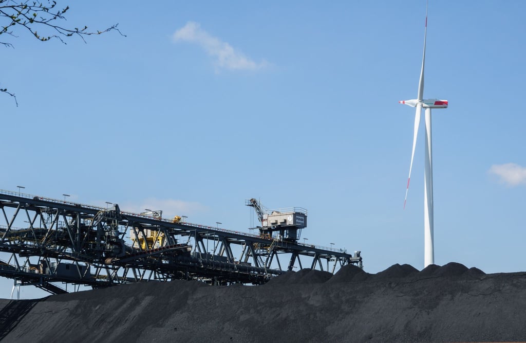 Steinkohle liegt in einem Kohlefaden in Sichtweite von Windrädern.