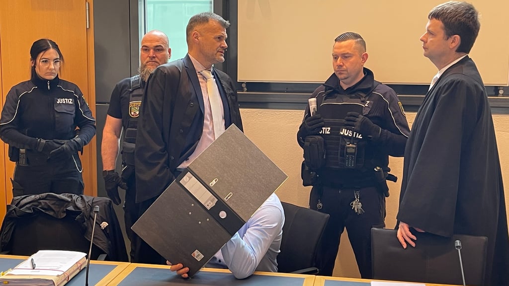 Der Angeklagte versteckte sich hinter einem Aktenordner kurz vor der Urteilsverkündung im Magdeburger Landgericht.