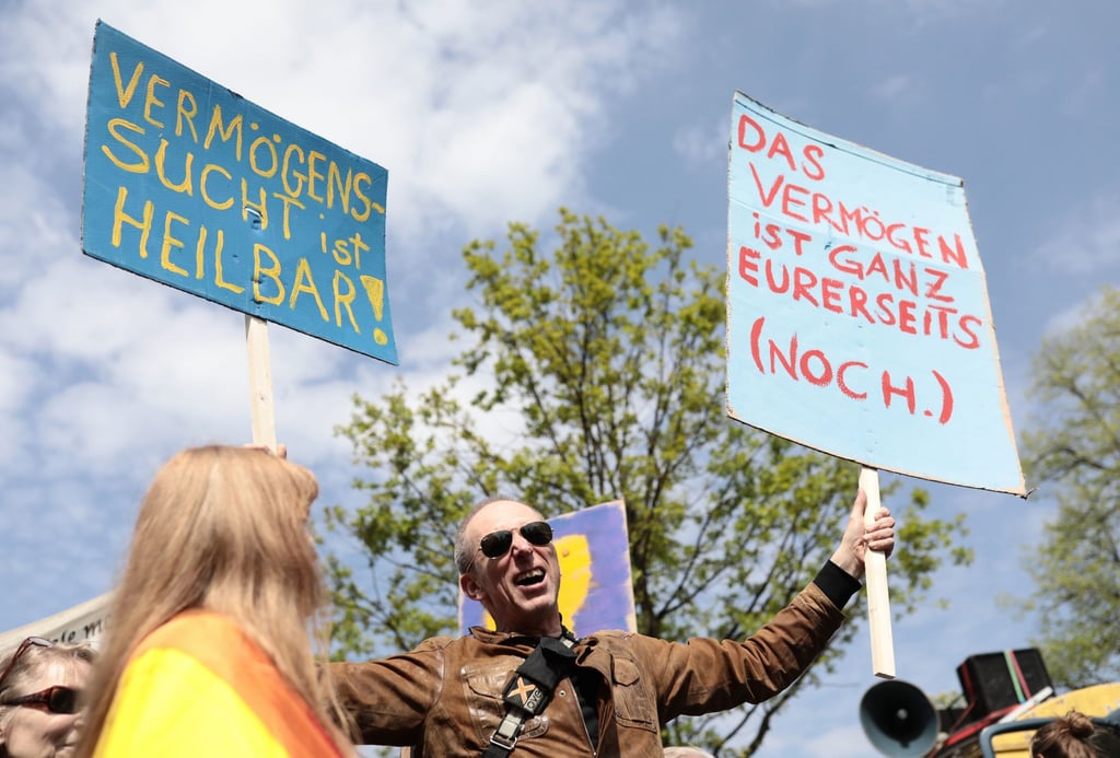 Teilnehmer demonstrieren mit Plakaten im Grunewald bei der Demonstration „my Gruni“.