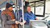    Busfahrer Christian Franke verkauft Kundin  Patel Anjanaben einen Fahrschein.