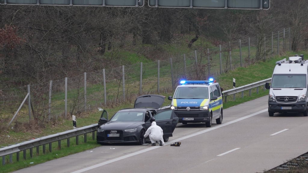 Ein PKW und ein Fahrzeug der Polizei stehen auf dem Standstreifen der Autobahn 1.