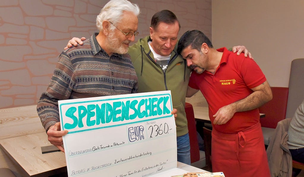 Roland Ritter und Gerald Kästner (v. li.) überreichen dem sichtlich gerührten Murat Özer eine Spende für seine Familie, die in Malatya lebt und vom Erdbeben und den Überschwemmungen in der Türkei betroffen ist.