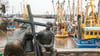Schwarze Holzkreuze lehnen an der Bronezeskulptur „Alt- und Jungfischer“ im Hafen in Neuharlingersiel. Das Fischen mit Grundschleppnetzen steht in der Kritik.