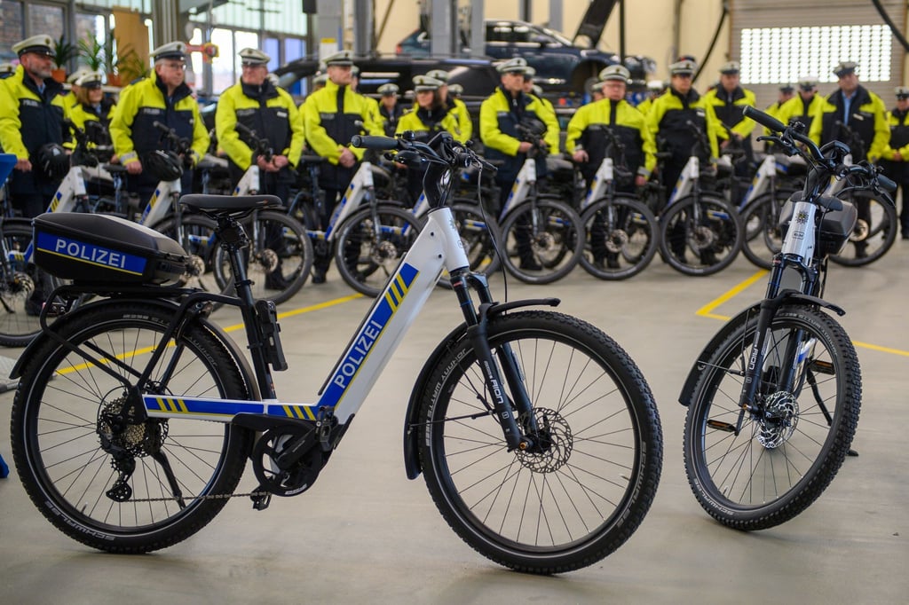 Polizistinnen und Polizisten stehen neben Pedelecs des Herstellers „Riese und Müller“.