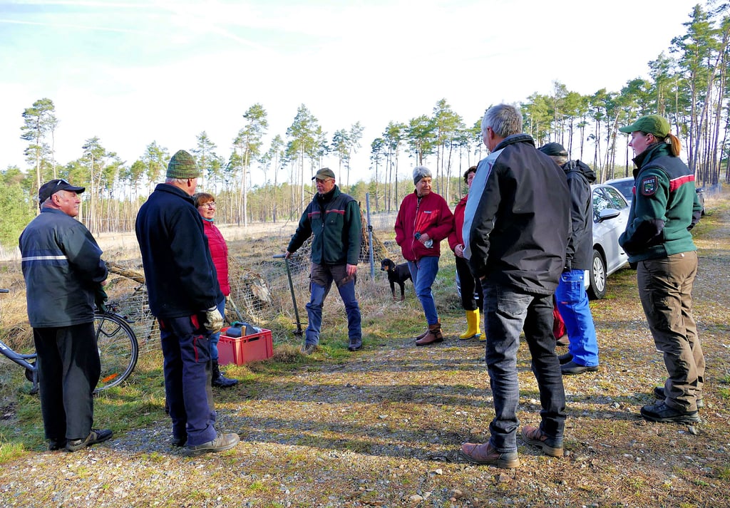 Mitglieder des Heimatvereins „Glücksburger Heide“ am Treffpunkt im Jessener Stadtwald: Revierförster Guido Arndt (Mitte) und Isabel Bohnen (rechts) weisen die Helfer ein. Es sollen 3.000 Kiefern gepflanzt werden.