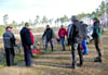 Mitglieder des Heimatvereins „Glücksburger Heide“ am Treffpunkt im Jessener Stadtwald: Revierförster Guido Arndt   (Mitte) und Isabel Bohnen (rechts) weisen die Helfer ein. Es sollen 3.000 Kiefern gepflanzt werden.  