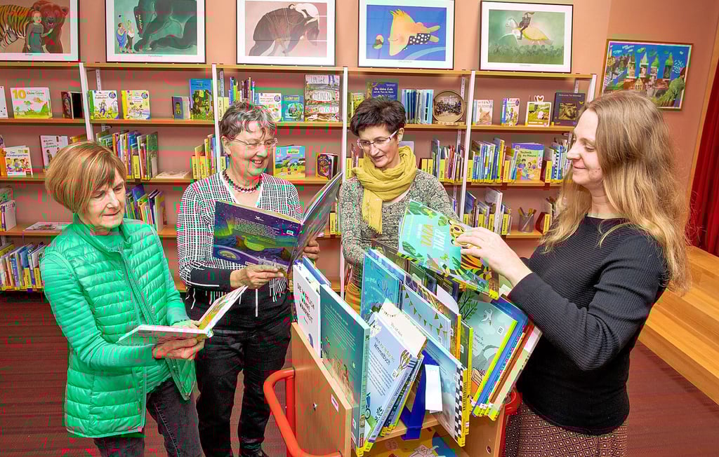 Die Lesepatinnen Edelgard Einicke (l.) und  Dorothee Sieber sowie die Bibliotheksmitarbeiterinnen Sandra Graneist und  Antje Key (r.) nehmen die Bilderbücher für das Projekt   schon einmal in Augenschein.