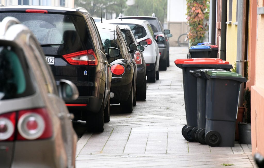 In einer Straße parken Autos auf dem Gehweg.