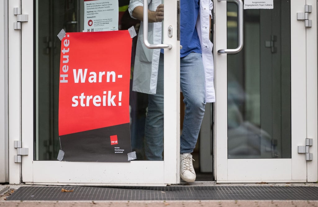 Ein Plakat mit der Aufschrift „Warnstreik“ hängt an der Tür einer Klinik.
