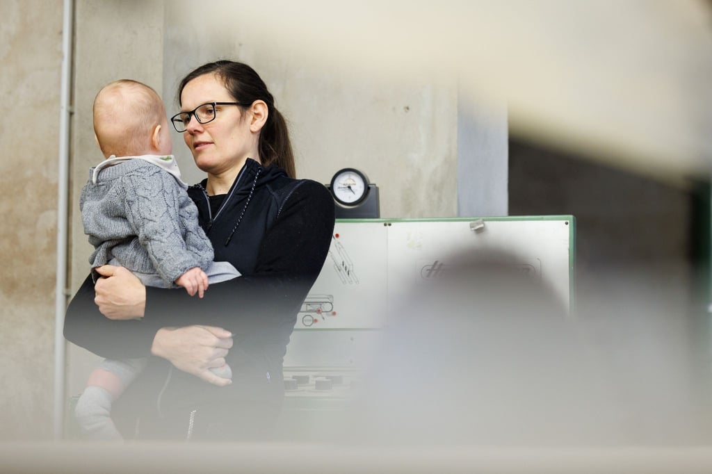 Tischlermeisterin Johanna Röh mit ihrem Kind in der Werkstatt ihres Betriebes.