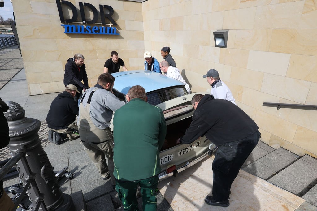Ein Trabant wird eine Rampe zum DDR Museum hinunter gerollt.