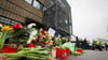 Blumen und Kerzen erinnern vor dem Eingangsbereich des Gemeindehauses in Hamburg an die Opfer der Amoktat.